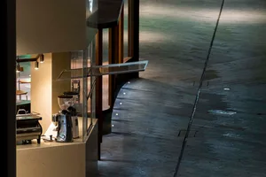 A minimalist coffee shop interior featuring metallic finishes and sleek design elements.