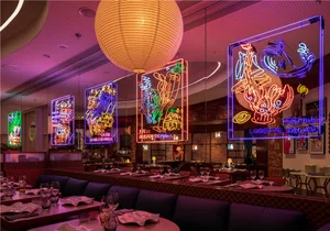 A photograph of a modern restaurant interior with colorful neon signs.