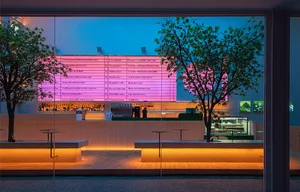 A modern coffee shop featuring neon ambient lighting and glass walls.