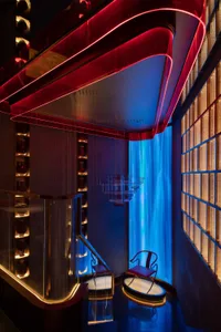 Modern hotel lobby with glass and metal design elements and red and blue lighting