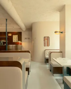 Industrial-style restaurant interior with concrete walls, metal decor, and minimalistic design.