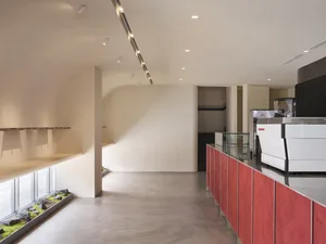 A modern cafe interior with a concrete floor and minimalist design elements.