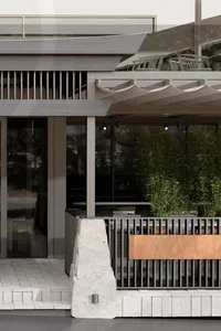 A modern restaurant exterior featuring natural stone and concrete materials.