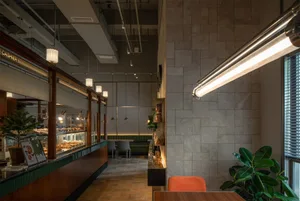A modern cafe interior with concrete walls, wooden tables, and metal accents.