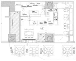 Black and white architectural blueprint of a restaurant layout showing various sections like kitchen and dining areas.