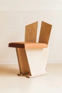 A modern, flat-pack wooden chair with a unique design.