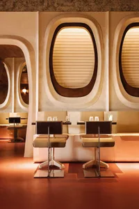 Modern restaurant interior with sleek booth seating and large windows.