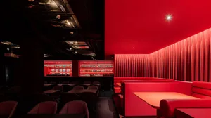 A modern restaurant bar with red curtains and a bright, cozy atmosphere.