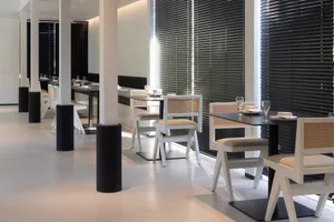 A modern restaurant interior with white furniture and black accents.