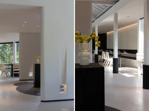 Modern minimalist interior with white concrete walls and floor, featuring sleek furniture and clean lines.
