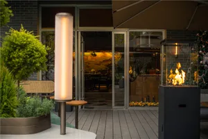A modern restaurant exterior showcasing glass panels, metal structures, and potted plants.