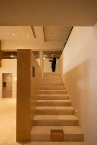 A modern stone staircase illuminated by ambient lighting within an elegant interior design setting.