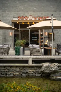 Modern restaurant exterior with brick, stone, and glass.