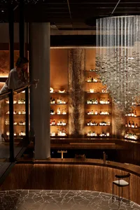 A modern bar area with wood, concrete, and glass materials.