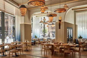 Industrial-themed restaurant interior with wooden tables and chairs.