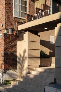A modern building exterior with a brick wall and concrete staircase.