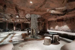 Industrial-style spa interior featuring a rocky cave-like setting with stone and water elements