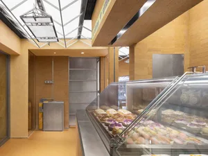 Modern bakery interior with concrete paneling and skylights