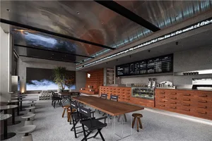 A modern restaurant interior with metallic ceiling, concrete walls, and wooden furniture.