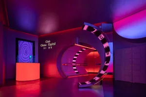 Modern nightclub interior with metal and glass structures and neon lights.