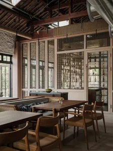 Modern restaurant interior with wooden tables, chairs, and exposed wooden beams and rafters.