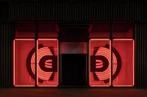 A modern retail storefront featuring illuminated neon signs.