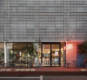 Modern restaurant exterior with a metallic facade and glass windows.