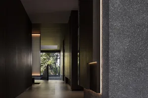 Modern entrance hall featuring concrete walls and flooring, with a view of the outdoors.
