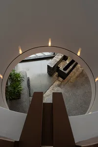 A modern living room featuring marble, concrete, and glass materials.