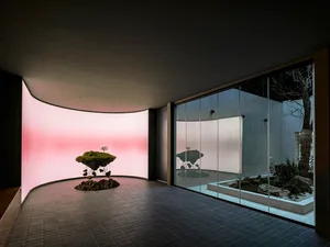 極簡藝術裝置，漂浮造型搭配綠植與岩石，置於現代粉色燈光空間。