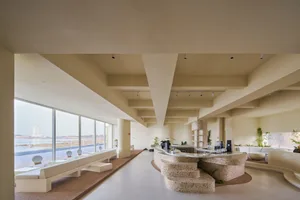 Interior of a modern hotel lobby featuring concrete and glass materials.