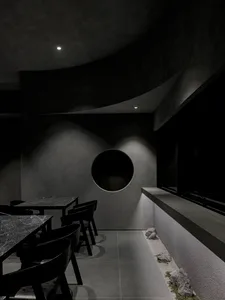 A modern industrial restaurant with concrete walls and tables.
