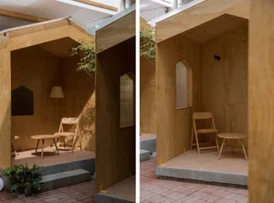 A minimalist space with wooden walls, floor, and furniture in a corridor or hallway.