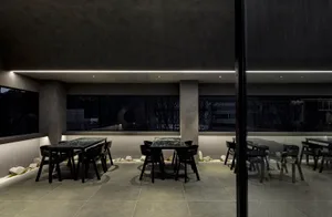 Modern restaurant interior with dark wood furniture and concrete floor