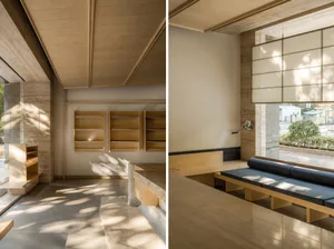 Interior of a modern coffee shop with wooden shelves and seating, and stone flooring.