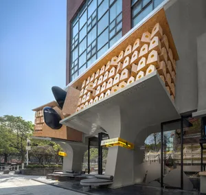 Modern storefront with metal cladding and intricate design elements on the facade.