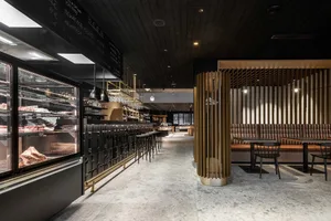 Industrial-style restaurant interior with black metal and wood finishes.