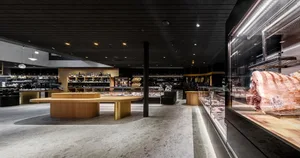 Modern restaurant interior featuring a wooden floor and counter.
