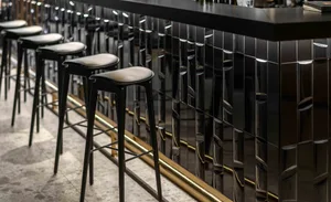 A modern industrial restaurant interior with a sleek, metallic bar counter.