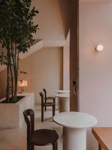 Modern cafe interior featuring marble cylinder tables and minimalist decor.