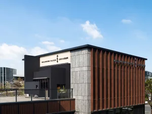 A modern restaurant building with a metal-clad exterior on a sunny day.