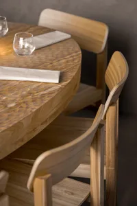 A modern restaurant interior with wooden furniture and a polished wooden table
