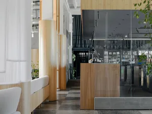 Modern cafe interior with wooden pillars and glass walls featuring contemporary design elements.