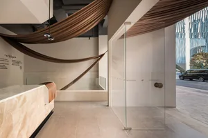 A modern minimalist retail storefront with glass, marble, and concrete materials.