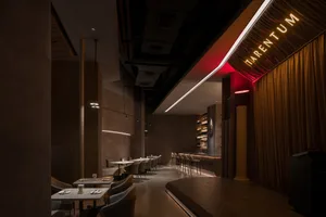 A modern restaurant interior with dark-toned materials and a sleek, contemporary design.