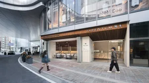 Modern restaurant with glass storefront and concrete entrance on a sidewalk.