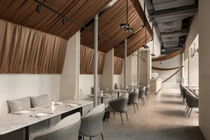 Industrial-style restaurant interior with metallic accents and glass elements.