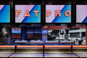 A modern restaurant bar featuring neon signs in blue and purple colors.