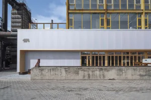 Industrial building featuring metal, concrete, and glass materials.