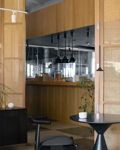 A modern industrial-style coffee shop interior with wooden elements and a black table.
